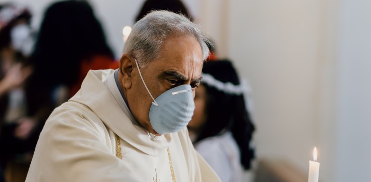 Catholic priest with a face mask in a church